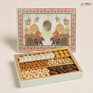 An open gift box of assorted Indian snacks and nuts, with the matching illustrated lid standing behind it on a light beige background. The box contains boxed sweets, almonds, cashews, pistachios, and dates.
