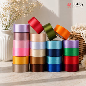 Stack of colorful ribbons with a Bakeyy logo in the corner.