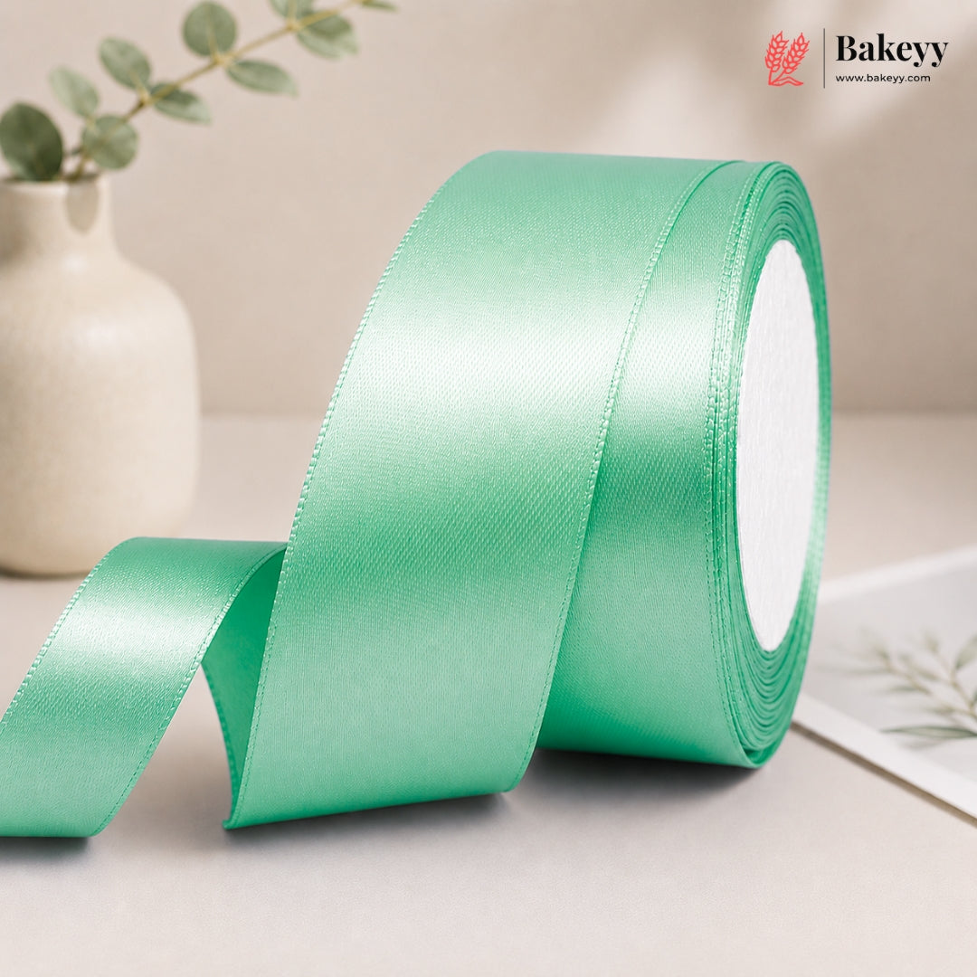 Green satin ribbon roll on a neutral background with 'Bakeyy' branding.