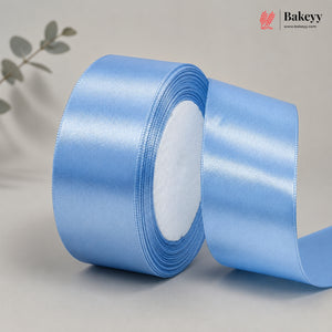 Roll of blue satin ribbon on a light gray background with 'Bakeyy' branding.