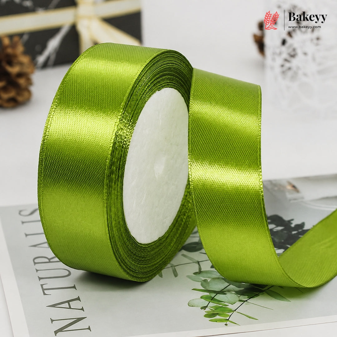 Green satin ribbon roll on a magazine with Bakeyy branding.