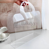 Clear acrylic cake stand with 'Bakeyy' branding on a neutral background