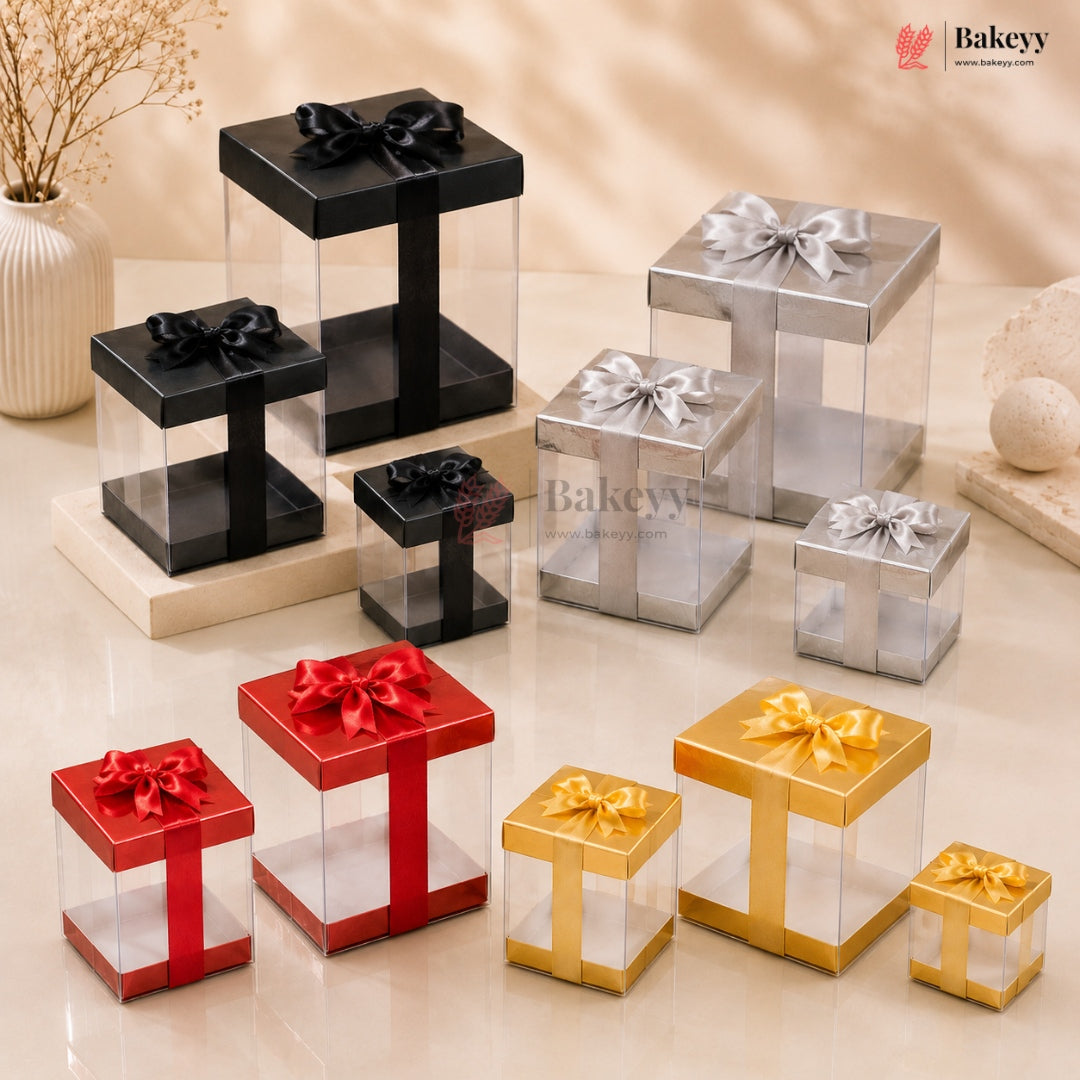 Collection of transparent gift boxes with colored ribbons and bows on a beige surface, featuring the Bakeyy brand.