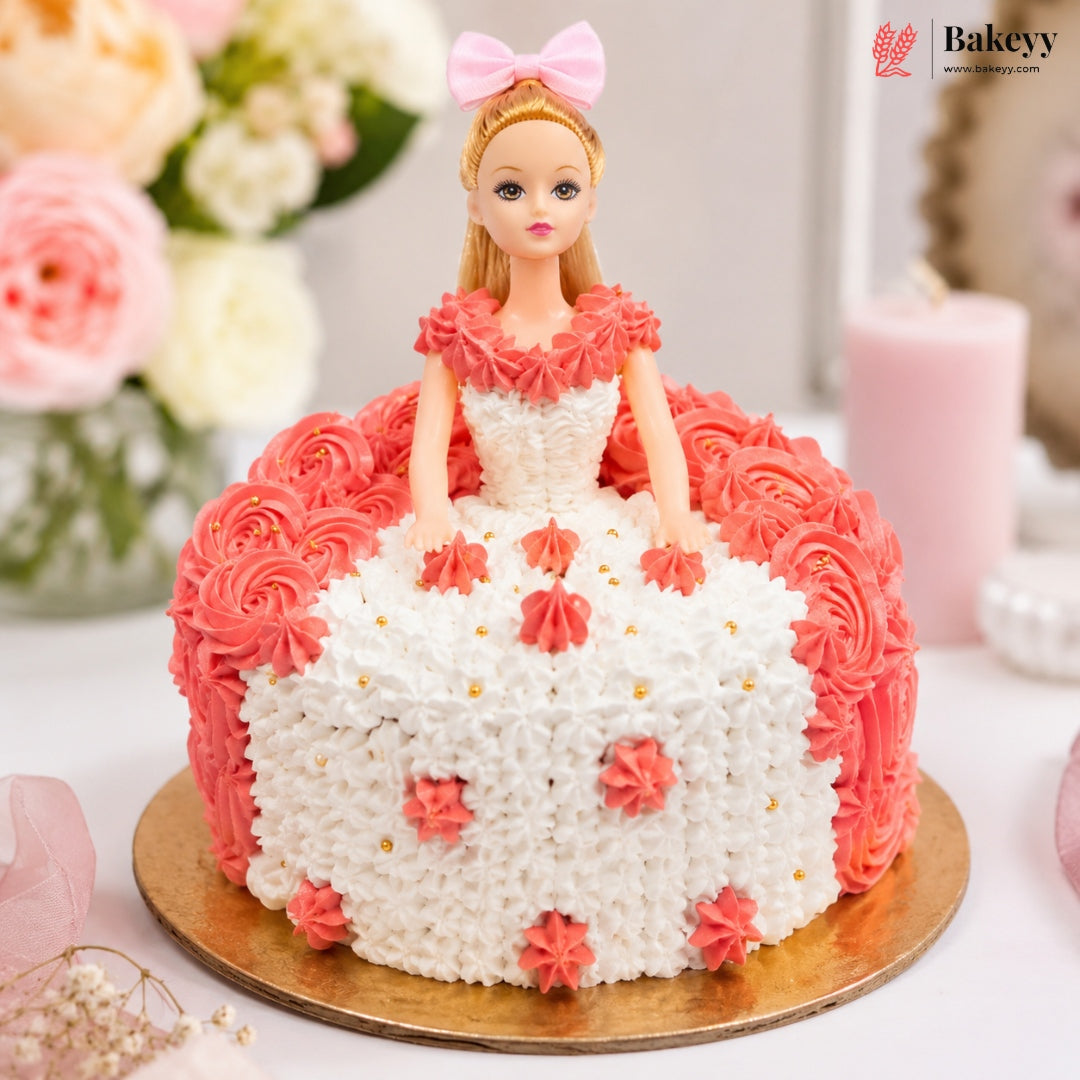 Barbie doll cake with pink and white frosting on a wooden board, surrounded by flowers and candles.