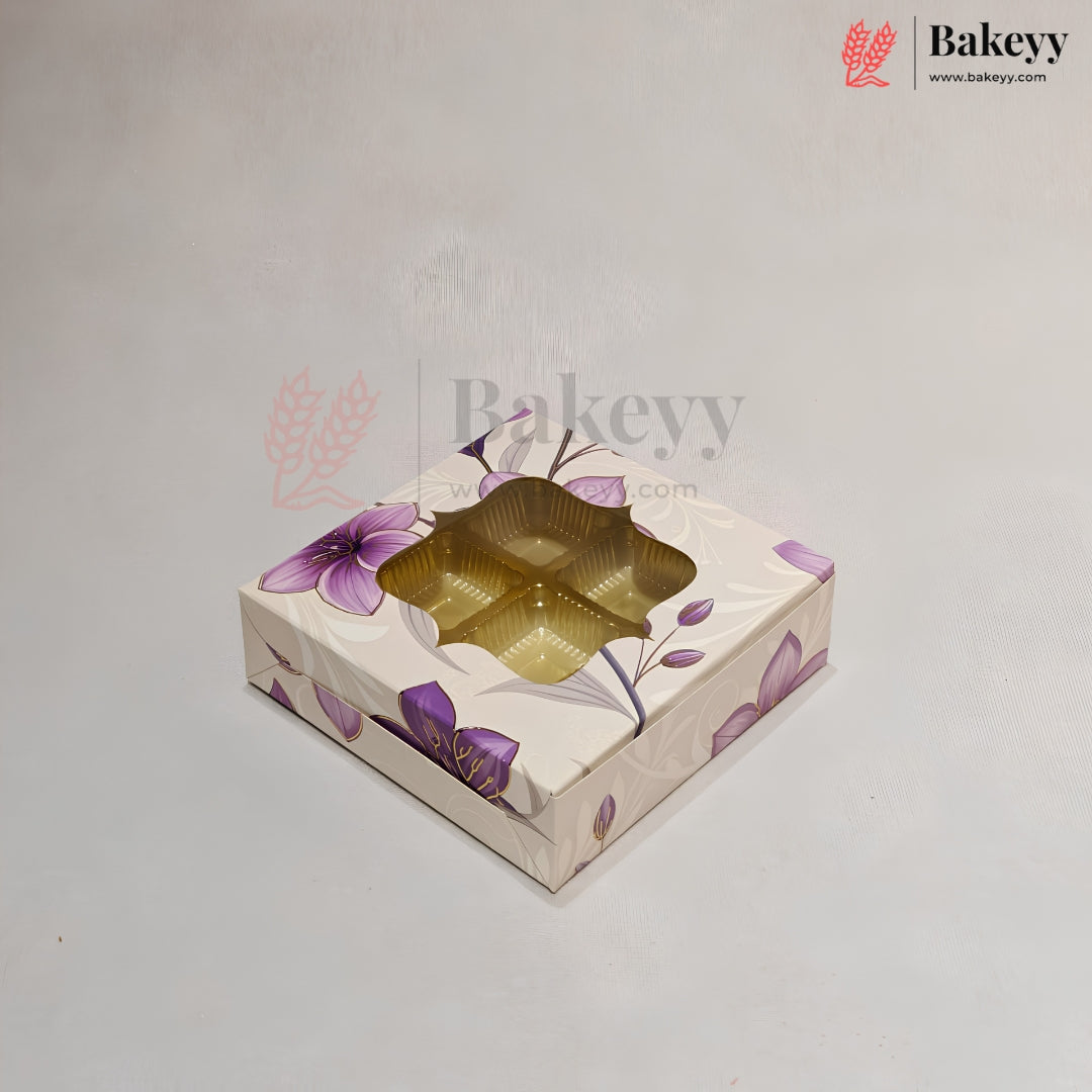 A square bakery gift box with a floral pattern in purple and beige, featuring a clear window that reveals a gold-colored tray inside, set against a light gray background.