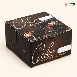 A square dark brown cardboard cake box with 'Cake celebration time' printed in white and gold script, decorated with a chocolate cake illustration on the lid, photographed on a light beige background.