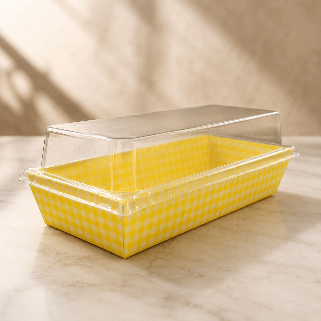 Yellow checkered food container with a clear lid on a light surface.