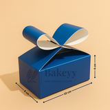 Blue gift box with a ribbon on a beige background, featuring the brand 'Bakeyy'.