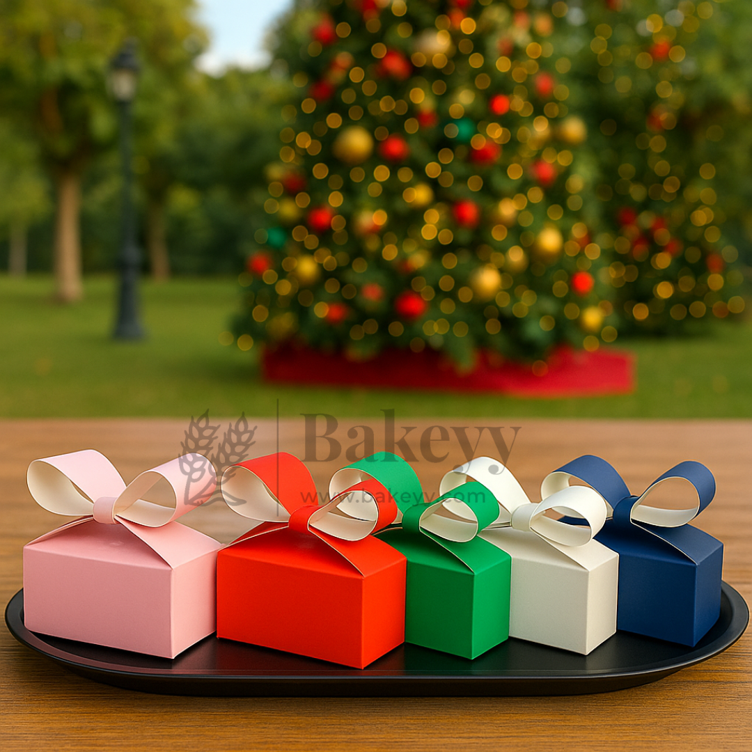 Colorful gift boxes with ribbons on a tray in front of a decorated Christmas tree.