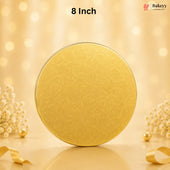 An 8-inch round gold-colored metal tin with a subtle embossed floral pattern, set against a warm, glowing bokeh background with decorative dried flowers and ribbons.