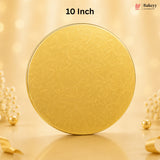 A round gold-colored tin with a subtle embossed floral pattern, standing upright on a reflective surface. The background is a warm, soft beige with bokeh lights and decorative pearl-like flowers.