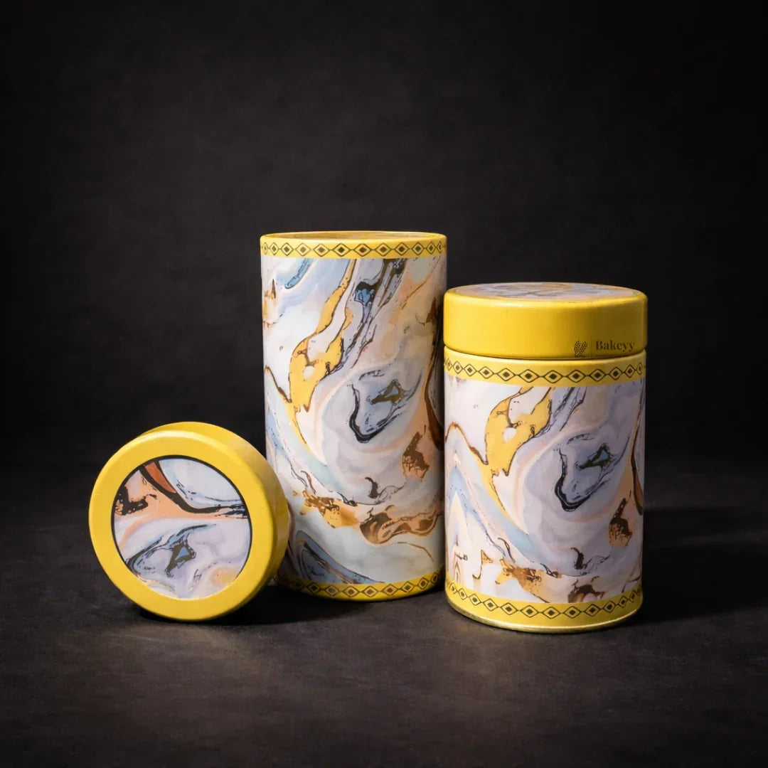 Round metal tin boxes with yellow lids and marble pattern, gift packaging by Bakeyy.com