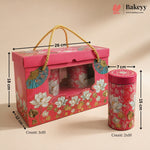 A pink floral bakery gift box with a rope handle and a matching cylindrical tin, shown with dimension arrows and counts on a beige background. The Bakeyy logo appears in the top right.