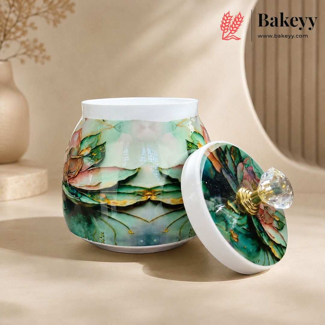 A ceramic jar with a matching lid, decorated with a green and teal floral pattern and gold accents, set against a warm beige background. The brand logo 'Bakeyy' is visible in the top right corner.