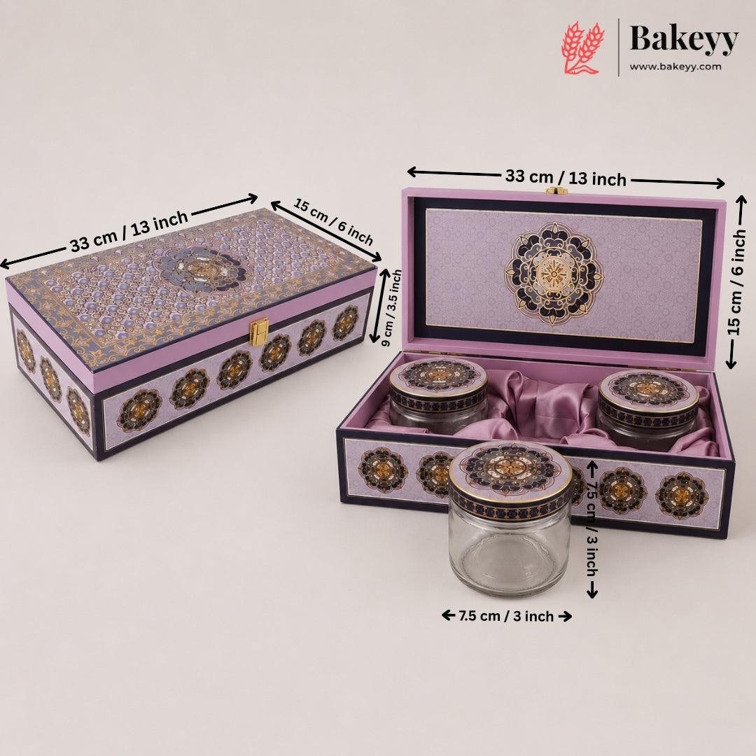 Decorative purple and gold ceramic tea set with a matching storage box, shown closed and open with dimension labels. The set includes a glass jar with a purple lid, two small ceramic jars with purple lids, and a larger open box containing the jars, all on a light gray background with Bakeyy branding.