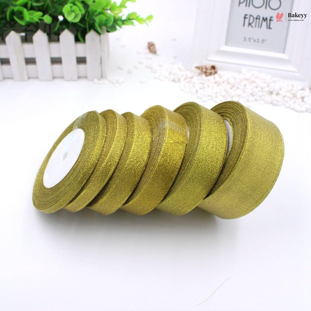 Gold ribbons on a white surface with a blurred background
