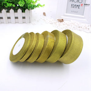 Gold ribbons on a white surface with a blurred background
