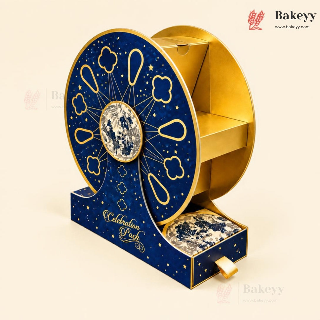A decorative gift box set for 'Celebration Puck' featuring a large circular wheel design in navy blue and gold with a central moon emblem, alongside a matching drawer containing marbled sweets, all on a light beige background.