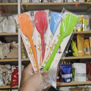 Set of colorful spatulas in packaging held by a hand with a store shelf in the background.