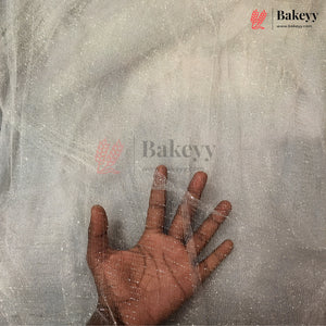 A hand placed on a translucent, textured sheet or mat to show its thickness and texture, with Bakeyy branding visible on the image.