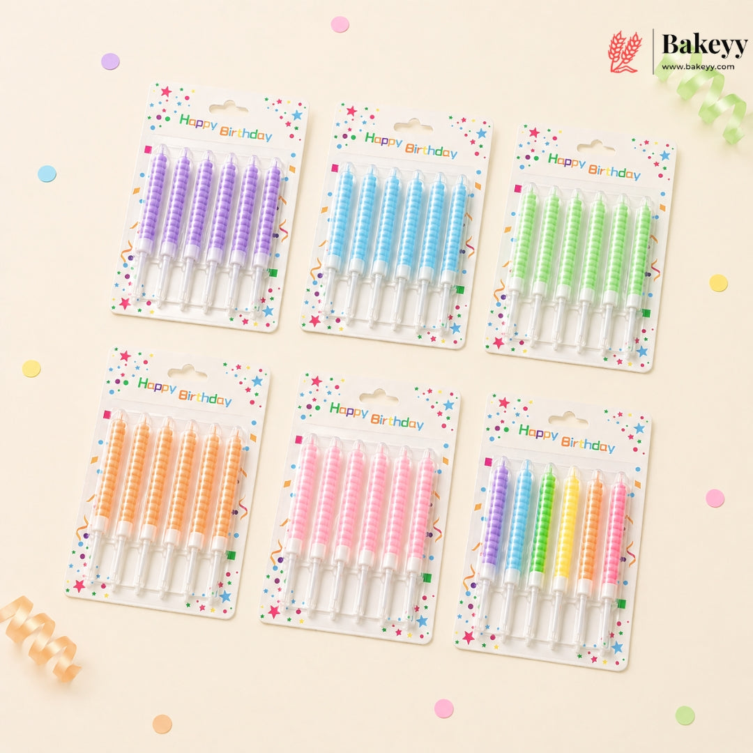 Set of colorful birthday candles in their packaging on a light beige background with confetti.