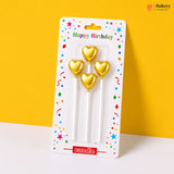 Gold heart-shaped candles in packaging with 'Happy Birthday' text on a yellow background