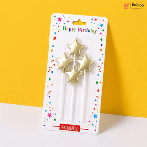 Packaged gold star-shaped birthday candles on a yellow background
