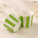 Green and white striped paper cupcake liners on a beige background