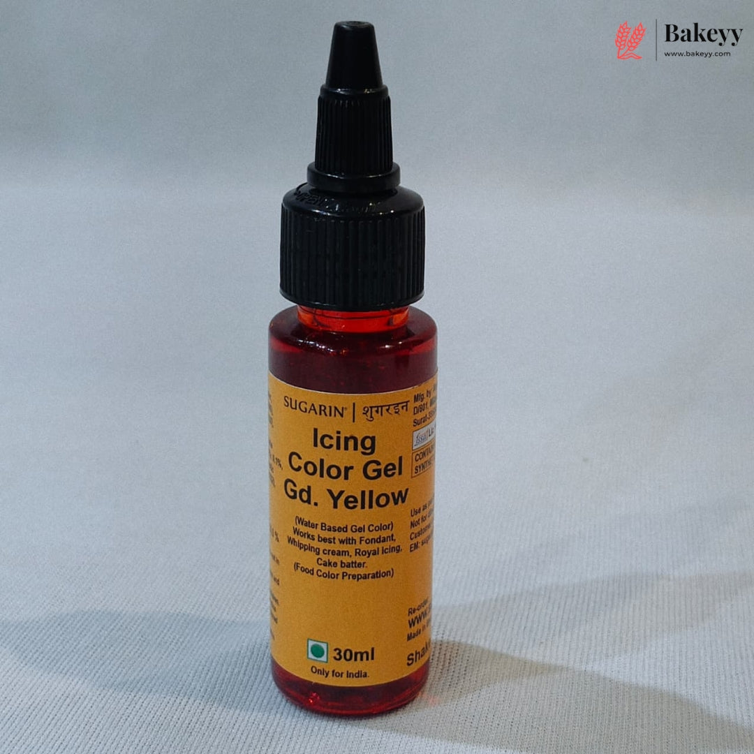 A 30ml bottle of Sugarin Icing Color Gel in the shade Gd. Yellow, featuring a black dropper cap and a yellow label, set against a light gray fabric background.