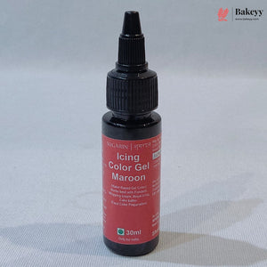 A 30ml bottle of Sugarin Icing Color Gel in Maroon, featuring a black plastic dropper cap and a red label, set against a light gray fabric background.