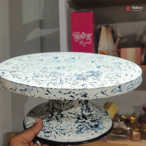 Speckled patterned cake stand held by a hand with a blurred background