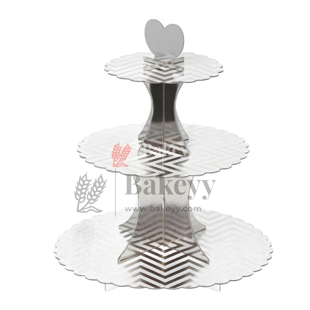 Three-tiered silver cake stand with decorative patterns on a white background, featuring the brand 'Bakevy'.