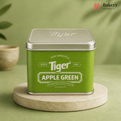 A square green tin of Tiger Apple Green synthetic food colour, displayed on a round beige stone coaster against a soft green background.