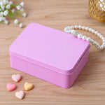 Pink tin gift box on wooden surface with pearl bracelet and heart-shaped candies, Bakeyy packaging