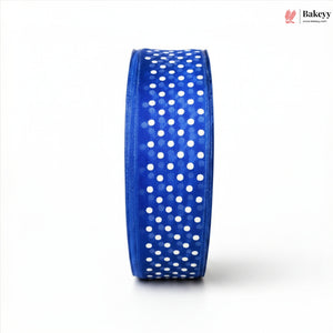 Roll of blue ribbon with white polka dots on a white background