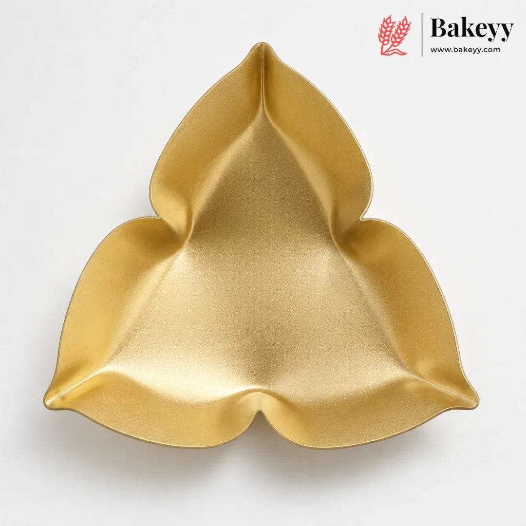 A gold-colored, three-petal shaped silicone baking pan shown from a top-down view on a white background, with the Bakeyy brand logo in the upper right corner.
