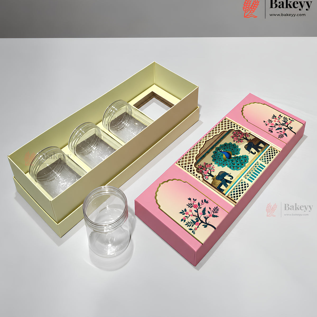 Three clear glass jars with screw-on lids presented in decorative packaging: one set inside a pale yellow rectangular box and one set inside a pink illustrated box, with one jar placed outside the packaging on a white surface.