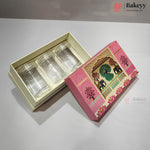 Three clear glass cups presented in a cream-colored tray inside a pink decorative gift box, with the illustrated lid placed beside it on a light gray surface.