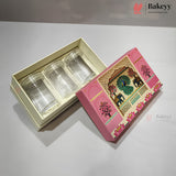 Three clear glass cups presented in a cream-colored tray inside a pink decorative gift box, with the illustrated lid placed beside it on a light gray surface.
