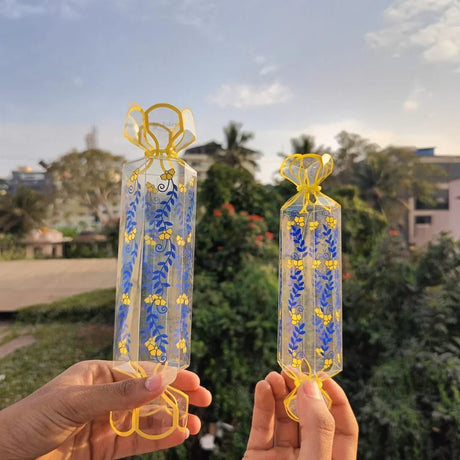 Clear transparent box with decorative floral print
Candy-style shape with twisted ends for a gift-ready look
Ideal for chocolates, candies, toffees, small treats, and favors
Great for birthdays, weddings, baby showers, festive gifting, and hampers
Lightweight, neat presentation, easy to display