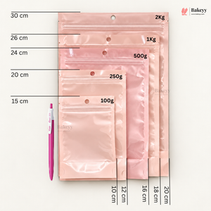 A set of translucent pink bakery bags in different sizes with printed weight labels (100g, 250g, 500g, 1Kg, 2Kg) and size measurements in centimeters, shown next to a pink pen on a white background. The Bakeey brand logo is visible in the top right.