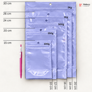 Five lavender plastic zip-top pouches of different sizes arranged vertically on a white background, with printed size measurements in centimeters and weight labels (100g, 250g, 500g, 1kg, 2kg) pointing to each pouch. A pink pen is shown to the left for scale, and the Bakecy logo appears in the top right corner.