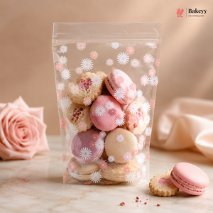 Clear bag with pink and white macarons on a marble surface with a pink rose.