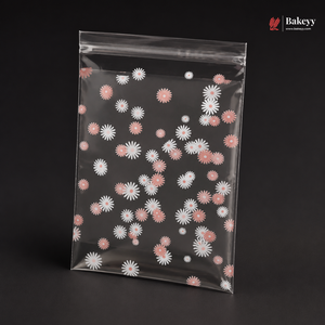 Clear plastic bag with pink and white floral pattern on a black background, featuring the brand 'Bakeyy'.
