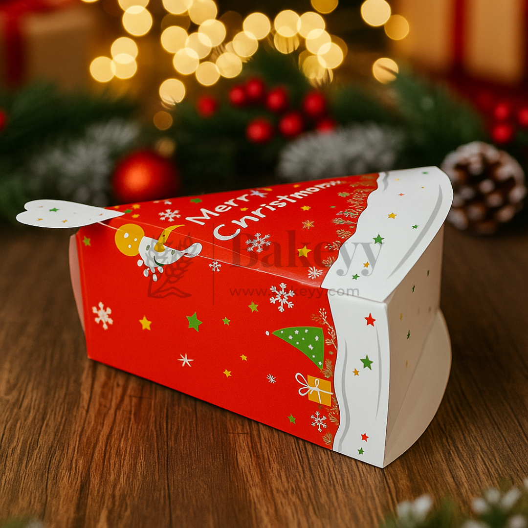 Red and white Christmas-themed gift box with 'Merry Christmas' text on a wooden surface with festive background.