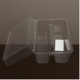 Clear plastic container with compartments on a dark surface