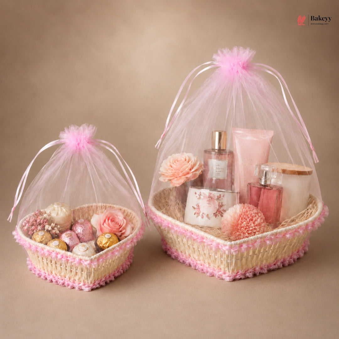 Two decorative baskets with pink tulle, flowers, and small items on a beige background.