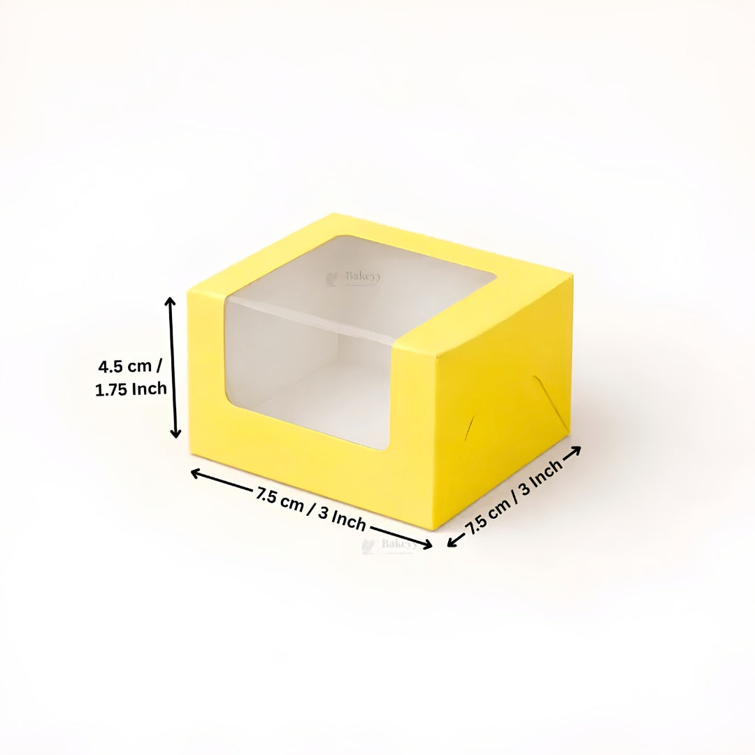 Yellow square box with a clear plastic window on top, shown with dimension arrows and text indicating measurements of 7.5 cm by 7.