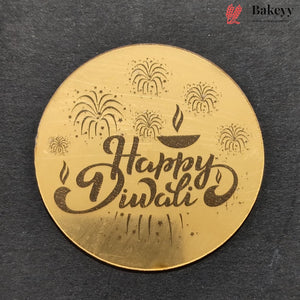 A round gold-colored metal plate engraved with 'Happy Diwali' in cursive script, surrounded by fireworks and a diya (oil lamp) motif, displayed on a dark textured background. The Bakeyy brand logo is visible in the top right corner.
