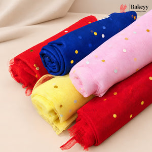 Four rolls of sheer mesh fabric in red, royal blue, pink, and yellow, each decorated with small metallic gold and silver confetti dots, arranged diagonally on a light beige surface.